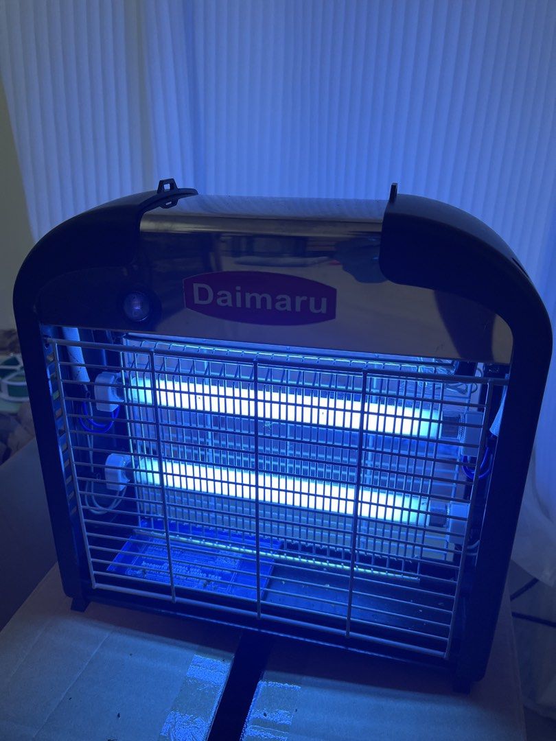 Daimaru Electronic Insect Killer Bug Zapper (Category: Pest Control) located in Manila. Submitted by curated.clutter12 (Listing ID 1470891532, Image 2). Description: - Brand: Daimaru Insect Killer Unit - Condition: Fully powered on with bright dual UV blue light tubes - Design: Sleek black and metallic silver with protective safety grids - Maintenance: Includes a removable bottom tray for efficient bug collection - Installation: Pre-installed han