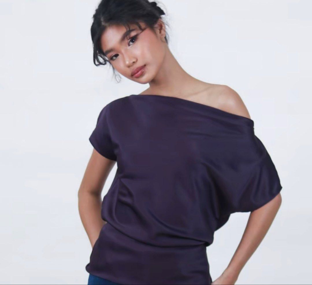 Dark Purple Satin Off-Shoulder Blouse with Back Tie (Category: Blouses) located in Manila. Submitted by clothesofitiew (Listing ID 1470774380, Image 1). Description: - Color: Dark purple with a subtle satin sheen - Neckline: Sleek off-shoulder design with short sleeves - Fit: Relaxed body fit with a built-in thin waist string to cinch the middle - Detail: Delicate thin tie closure at the upper back - Brand New - Size: M-L (check size chart in the