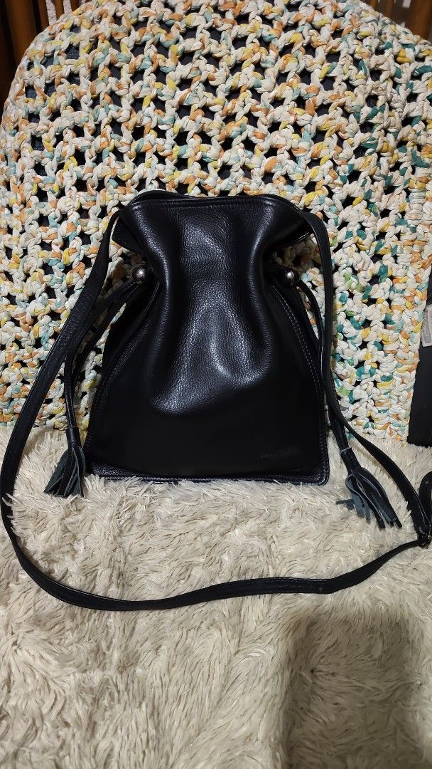 Deco...Black Leather Drawstring Crossbody Bag with Tassels (Category: Cross-body Bags) located in Cebu City. Submitted by lumaynojes00490 (Listing ID 1470825844, Image 3). Description: - Color & Material: Classic black with soft textured leather grain - Closure & Hardware: Drawstring closure with sleek round silver-tone accents - Details: Trendy side tassels on pull cords and a structured square bottom base - Strap: Adjustable thin leather should