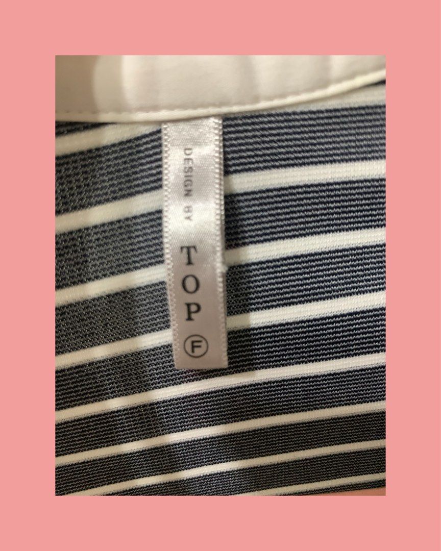 Design by Top Sailor Collar Button Down Blouse (Category: Blouses) located in Mandaluyong City. Submitted by mamalove70 (Listing ID 1470782111, Image 3). Description: White button-down blouse with navy blue and white stripes across the shoulders and back. Features a classic collar, chest pocket, and button closure down the back. Long sleeves can be rolled up and secured with button tabs. Tag shows size F. Clean and well-maintained condition..