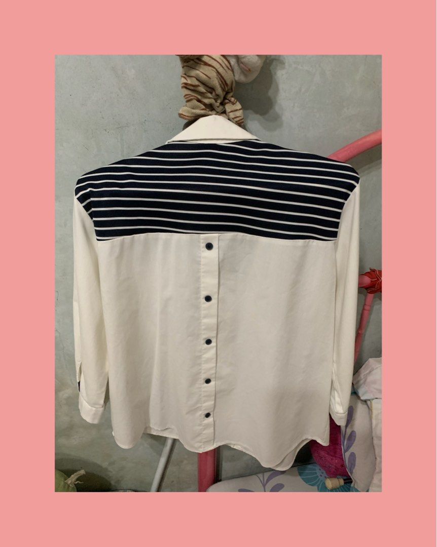 Design by Top Sailor Collar Button Down Blouse (Category: Blouses) located in Mandaluyong City. Submitted by mamalove70 (Listing ID 1470782111, Image 2). Description: White button-down blouse with navy blue and white stripes across the shoulders and back. Features a classic collar, chest pocket, and button closure down the back. Long sleeves can be rolled up and secured with button tabs. Tag shows size F. Clean and well-maintained condition..