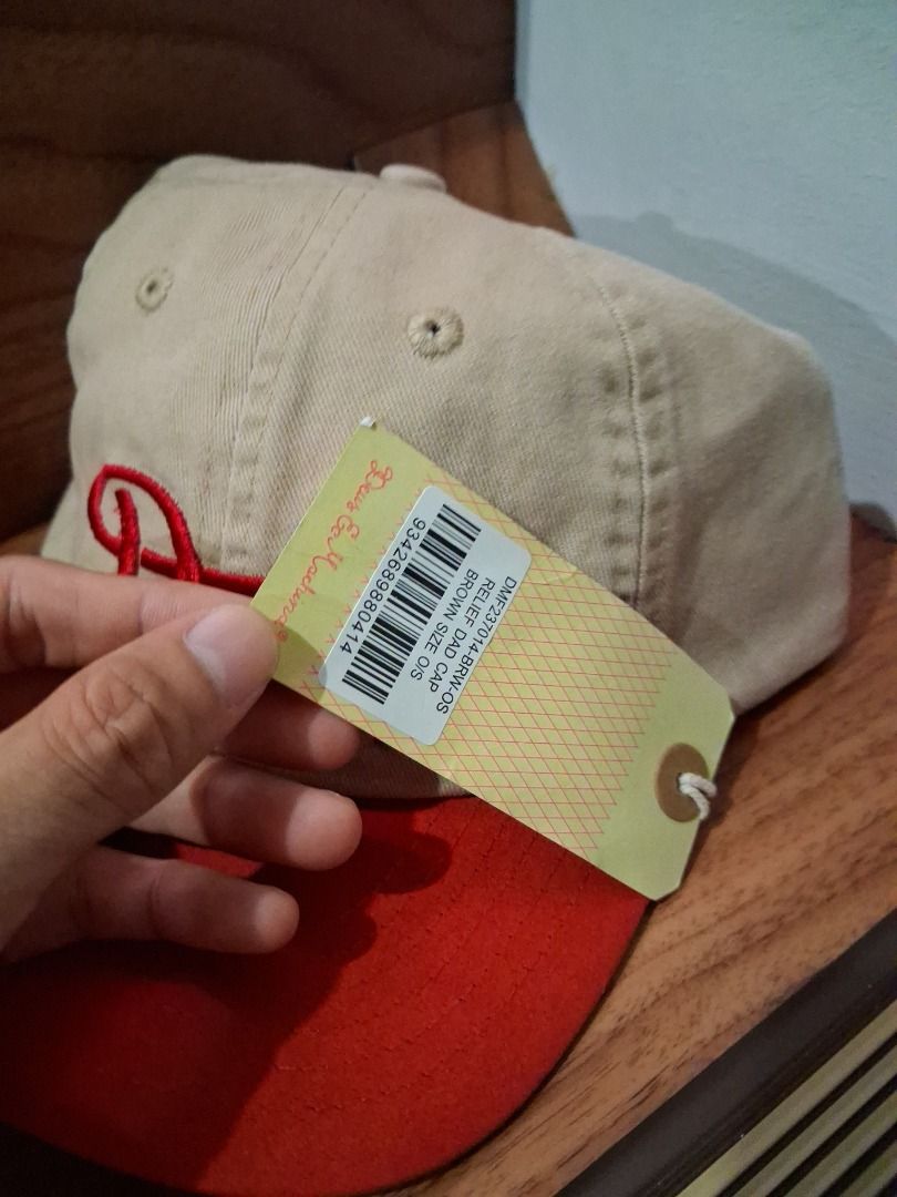 Deus Ex Machina Relief Dad Cap Brown Red (Category: Caps & Hats) located in Quezon City. Submitted by 357oclock (Listing ID 1470757016, Image 2). Description: - Brand: Deus Ex Machina - Condition: Brand new with original tags attached - Color: Brown and red - Design: Classic curved brim with embroidered logo on front and text embroidery on back strap - Closure: Adjustable metal clasp.