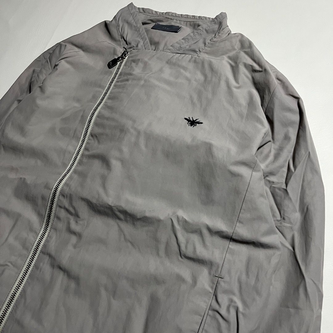 Dior Homme Grey Asymmetrical Zip Jacket with Embroidered Bee (Category: Coats, Jackets and Outerwear) located in Caloocan City. Submitted by achilles_grails (Listing ID 1470830657, Image 3). Description: - Brand: Dior - Item: Lightweight Grey Nylon Bomber Jacket - Closure: Unique asymmetrical front zip - Details: Iconic embroidered black bee logo on the chest - Trim: Ribbed collar, cuffs, and hem for a classic fit - Authenticity: Tagged neck labe