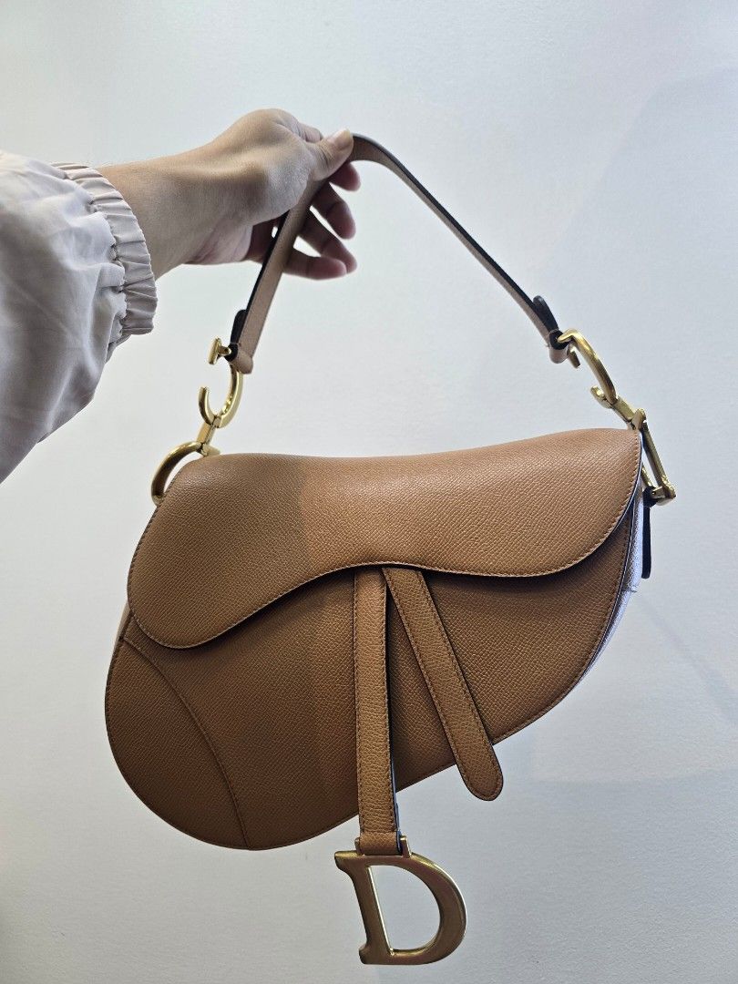 Dior Saddle Medium Golden Camello Bag (Category: Luxury Bags & Wallets) located in Taguig. Submitted by mluxeph (Listing ID 1470788668, Image 1). Description: Dior Saddle Medium Golden Camello Bag Material: Grained calfskin leather Stamp: 09 MA 0271 Year: 2021 Interior: One zip pocket and one main compartment Measurements: 10”L X 2.5”W X 8”H Handle Drop: 7" Hardware: Gold tone Inclusions: Original box, original dust bag and care booklet.
