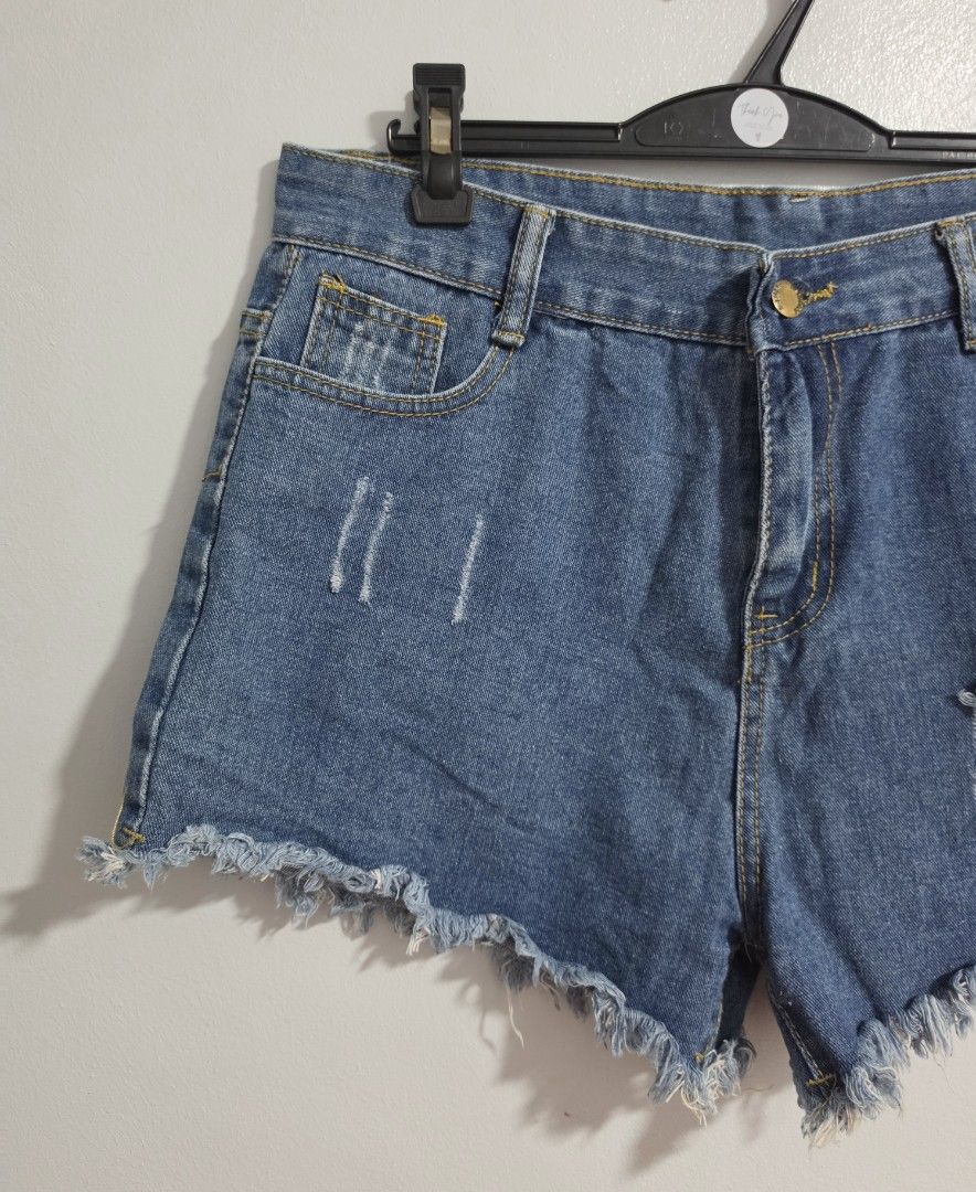 Distressed Denim Shorts Raw Hem Size 32 (Category: Shorts) located in Paranaque City. Submitted by franinnashop (Listing ID 1470850563, Image 3). Description: Declutter - Style: Blue denim shorts with heavy distressing and rips on front and back pockets - Details: Raw frayed hem and chic gold-tone button fly closure - Perfect for casual outings and effortless streetwear looks.