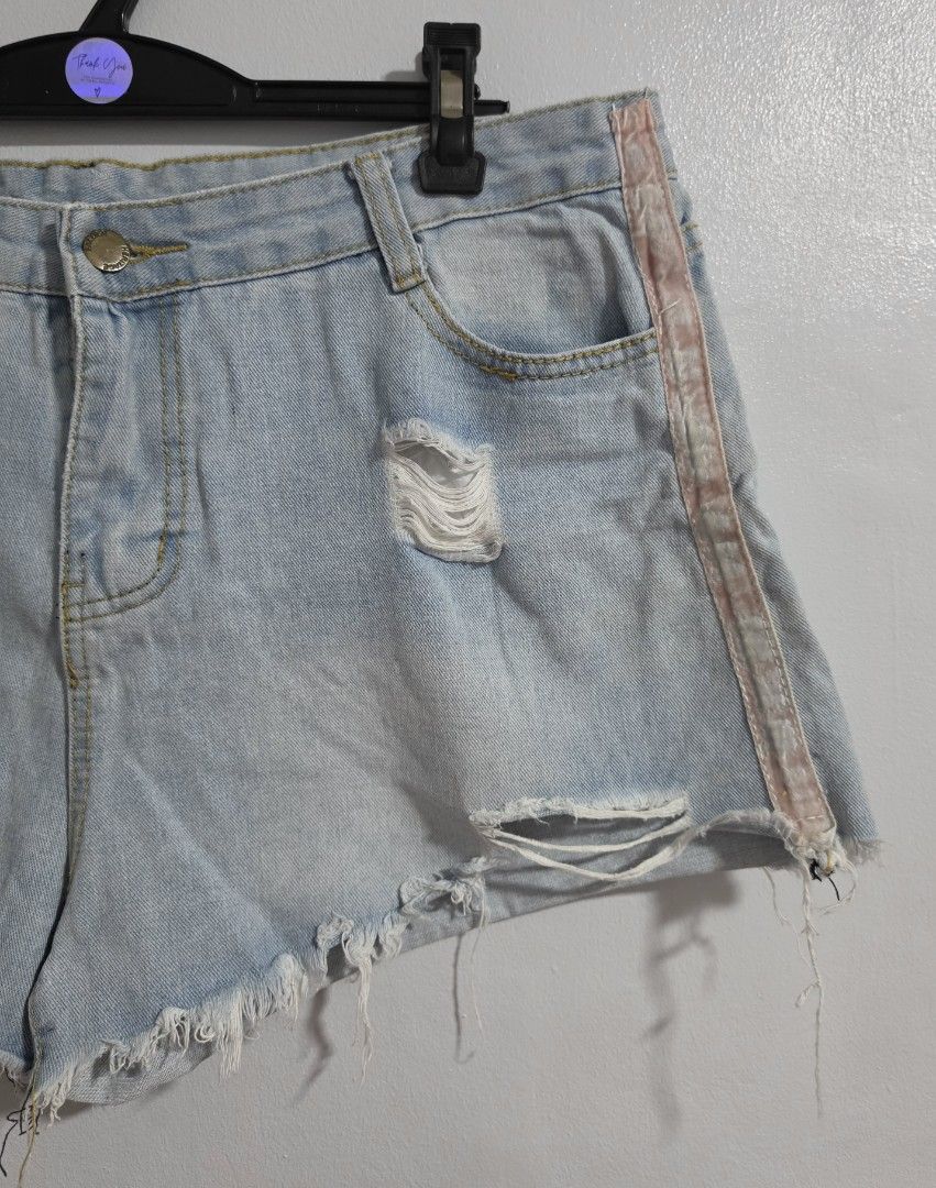 Distressed Light Wash Denim Shorts with Side Stripe (Category: Shorts) located in Paranaque City. Submitted by franinnashop (Listing ID 1470850269, Image 2). Description: Declutter - Style: Light wash denim shorts with distressed front rips and frayed raw hems - Detail: Unique faded pink side stripes on both legs - Closure & Fit: Button fly with belt loops - Pockets: Classic 5-pocket design (two front, one coin, two back patch) - Measurements: Wa