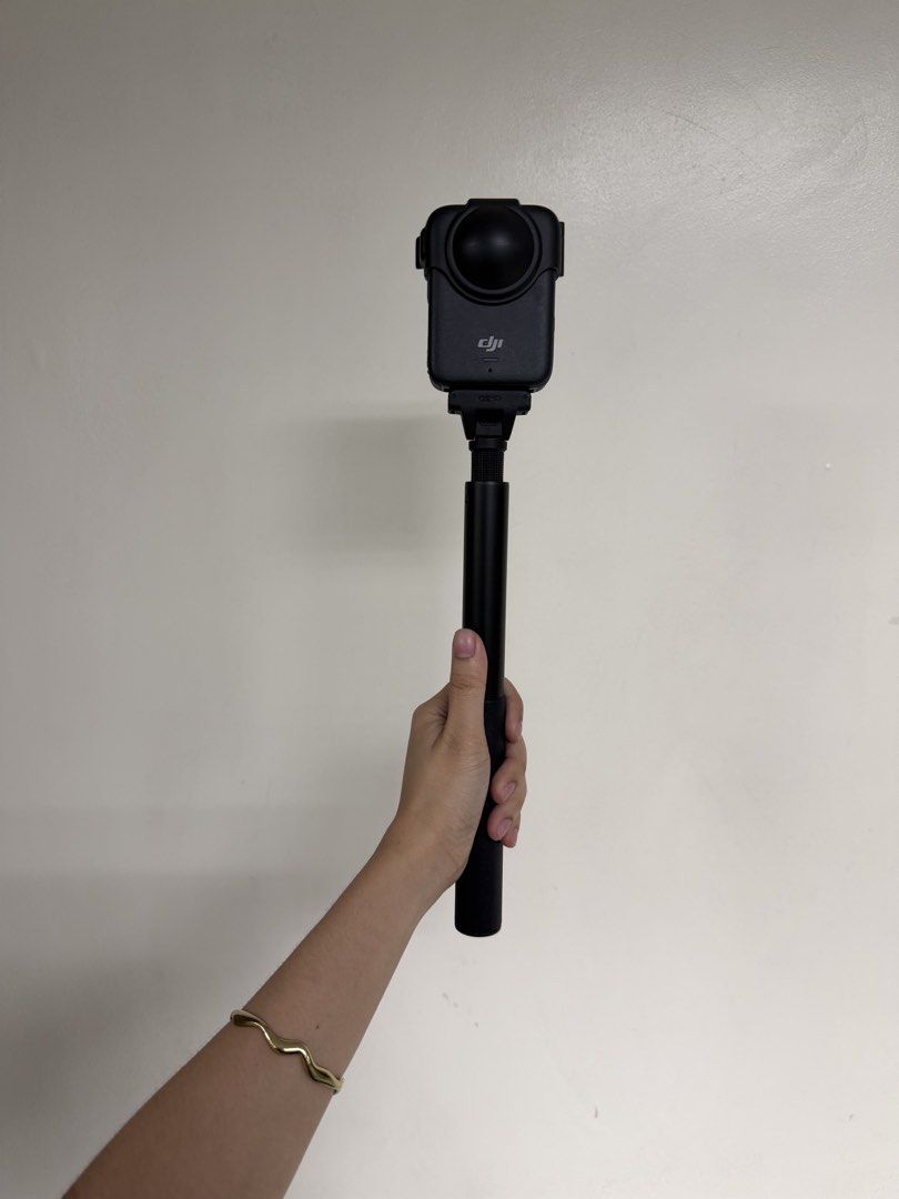 DJI Osmo Action Camera 360 with Extension Rod (Category: Video Cameras) located in Bacoor. Submitted by shopthenrock (Listing ID 1470885020, Image 1). Description: - Model: DJI Osmo Action Camera in sleek black finish - Condition: Fully functional and powered on with an active display - Features: Dual screens and a bulbous lens guard - Inclusion: Comes with an extension rod for better reach - Use: Designed with a gripped handle for steady recordi