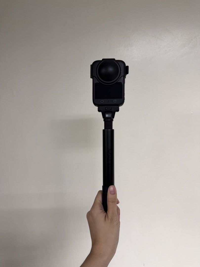 DJI Osmo Action Camera 360 with Extension Rod (Category: Video Cameras) located in Bacoor. Submitted by shopthenrock (Listing ID 1470885020, Image 2). Description: - Model: DJI Osmo Action Camera in sleek black finish - Condition: Fully functional and powered on with an active display - Features: Dual screens and a bulbous lens guard - Inclusion: Comes with an extension rod for better reach - Use: Designed with a gripped handle for steady recordi