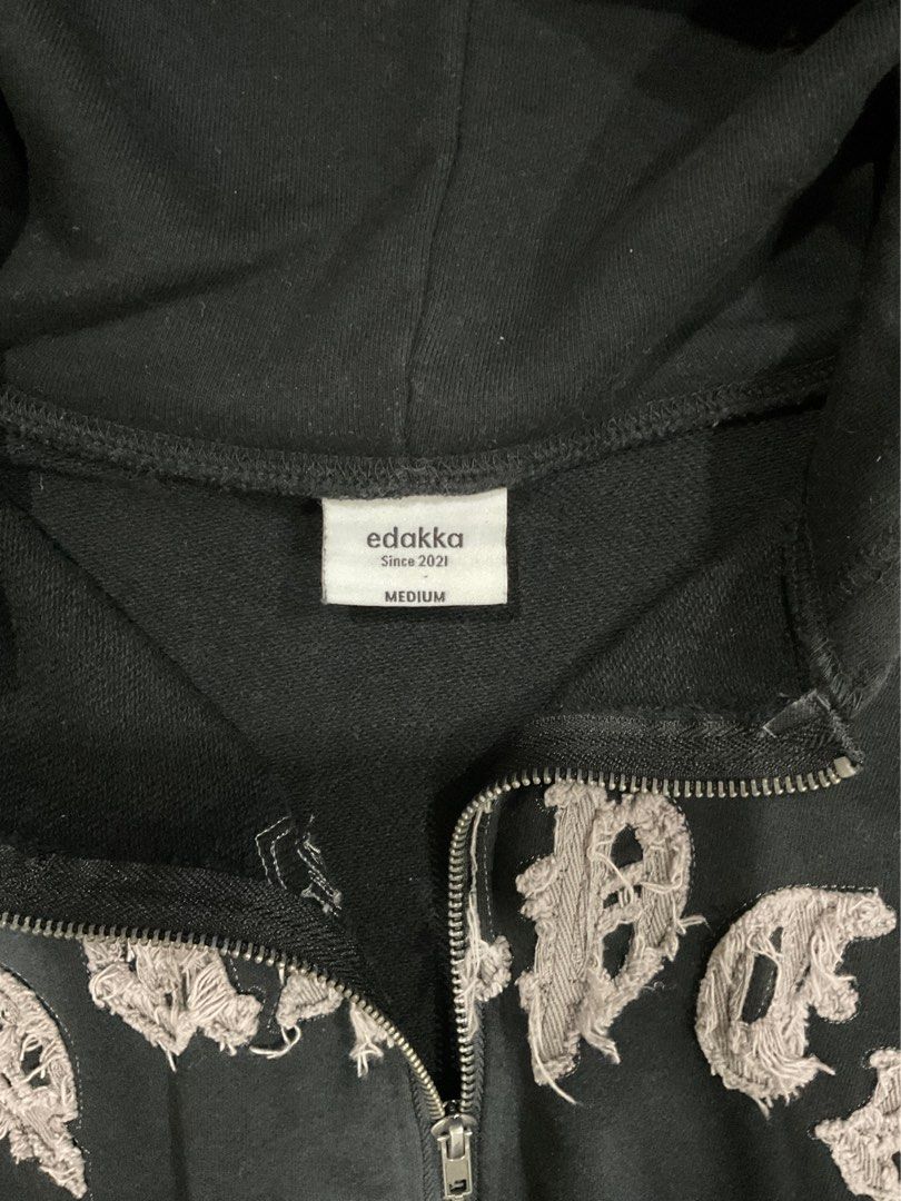 edakka Since 2021 Black Zip Hoodie Medium (Category: Hoodies) located in Manila. Submitted by bnyonyo (Listing ID 1470796244, Image 2). Description: - Brand/Model: Edakka zip hoodie - Color: Black with acid wash effect - Size: Medium - Design: Distressed applique lettering on chest & sleeve graphic - Features: Full zip closure, hood, and front pockets - Style: Comfortable everyday weight, perfect for streetwear.