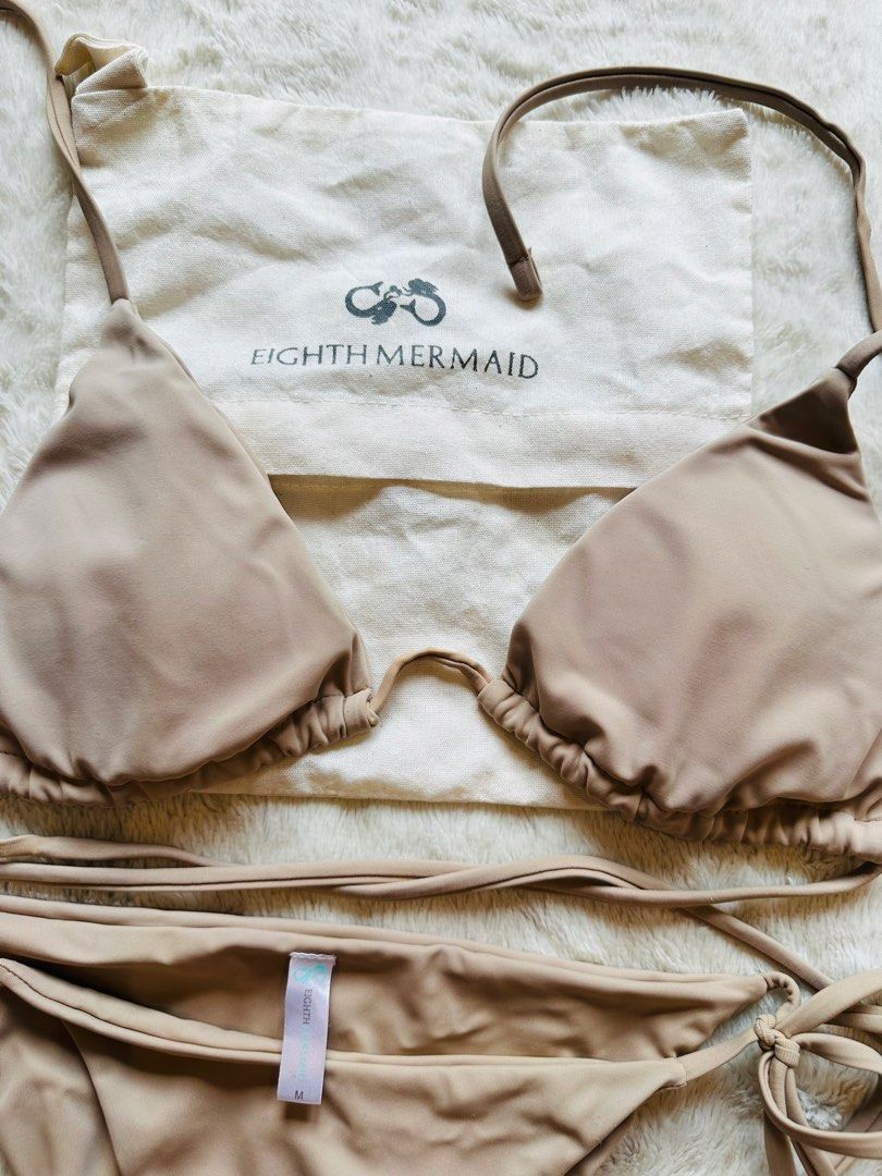 Eighth Mermaid Nude Bikini Set Size M (Category: Bikinis & Swimsuits) located in Marikina City. Submitted by zarahlovestoshop (Listing ID 1470795299, Image 1). Description: - Brand: Eighth Mermaid - Style: Two-piece bikini set with triangle top and side-tie bottoms - Color: Nude taupe - Size: Medium (tag attached) - Inclusions: Original branded dust bag - Condition: Clean, smooth fabric, classic adjustable fit.