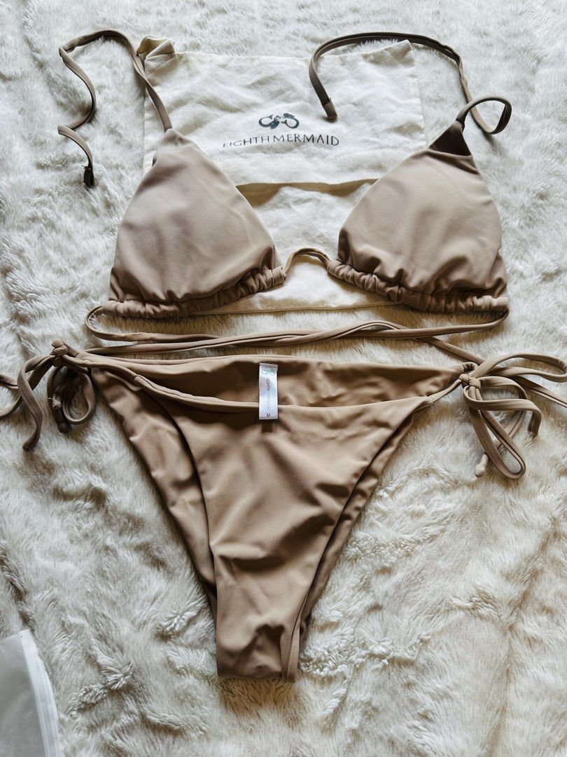 Eighth Mermaid Nude Bikini Set Size M (Category: Bikinis & Swimsuits) located in Marikina City. Submitted by zarahlovestoshop (Listing ID 1470795299, Image 2). Description: - Brand: Eighth Mermaid - Style: Two-piece bikini set with triangle top and side-tie bottoms - Color: Nude taupe - Size: Medium (tag attached) - Inclusions: Original branded dust bag - Condition: Clean, smooth fabric, classic adjustable fit.