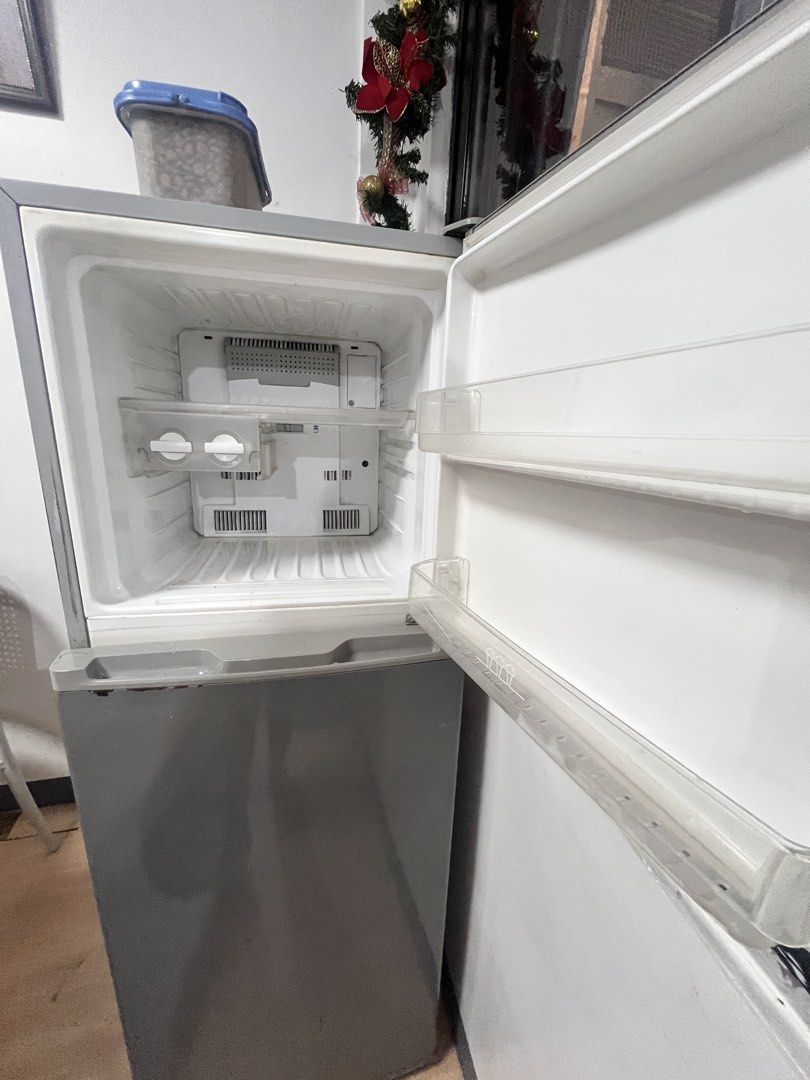 Electrolux White-Westinghouse Two Door Refrigerator Grey (Category: Refrigerators and Freezers) located in Del Monte. Submitted by jennyluistro (Listing ID 1470931868, Image 3). Description: - Brand/Model: Electrolux White-Westinghouse two-door fridge - Color: Grey with travel and decorative magnets on the front door - Layout: Top freezer compartment and bottom main fridge section - Features: Interior glass shelves, crisper drawer, and door bins 