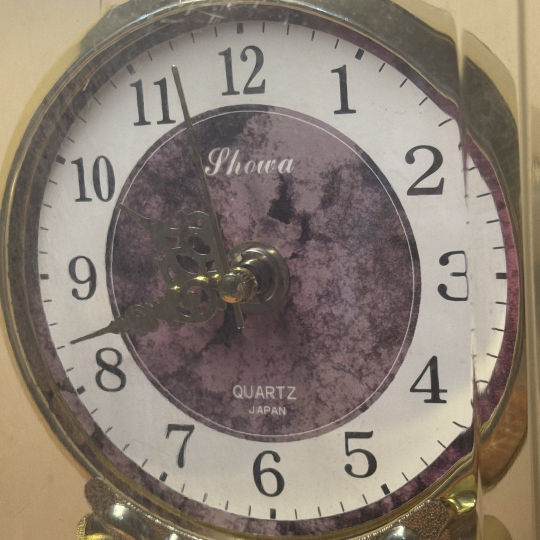 Elegant Japanese Showa Exceed Dome Table Clock with Marble-Pattern Dial (Category: Clocks) located in Pasig City. Submitted by msjazzylad (Listing ID 1470905527, Image 3). Description: Brand/Movement: Showa Exceed Quartz (Japan Movement) Design & Features: Elegant glass/acrylic dome cover with gold twin pillar support design. Unique purple marble-textured clock face with vintage-style hands and clear numeric markers. Classic dark wood-finish base