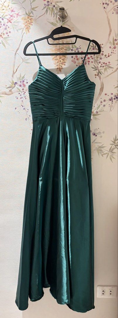 Emerald Green Satin Spaghetti Strap Maxi Dress (Category: Dresses) located in Cavite. Submitted by eunizcaimol (Listing ID 1470915278, Image 1). Description: - Color & Material: Emerald green, silky satin with a slight sheen - Design: Spaghetti straps, pleated bust detailing, and flowy floor-length skirt - Back Details: Corset-style lace-up design with adjustable ribbon ties - Size: 36B bust, 30 waist, 5’2 ht - Condition: Worn once for a wedding,