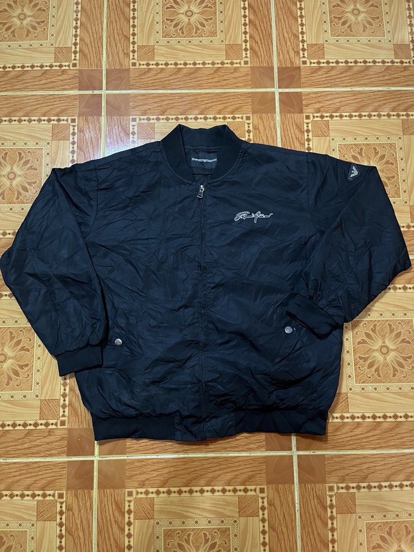 Emporio Armani Black Bomber Jacket (Category: Coats, Jackets and Outerwear) located in Kidapawan. Submitted by azythrift (Listing ID 1470822860, Image 1). Description: - Authentic Emporio Armani black bomber jacket 23x26 unisex - Classic ribbed collar, cuffs, and hem for a snug fit - Secure front zip closure with convenient waist snap-button pockets - Stylish embroidered script logo on the chest - Signature small eagle patch on the left sleeve - 