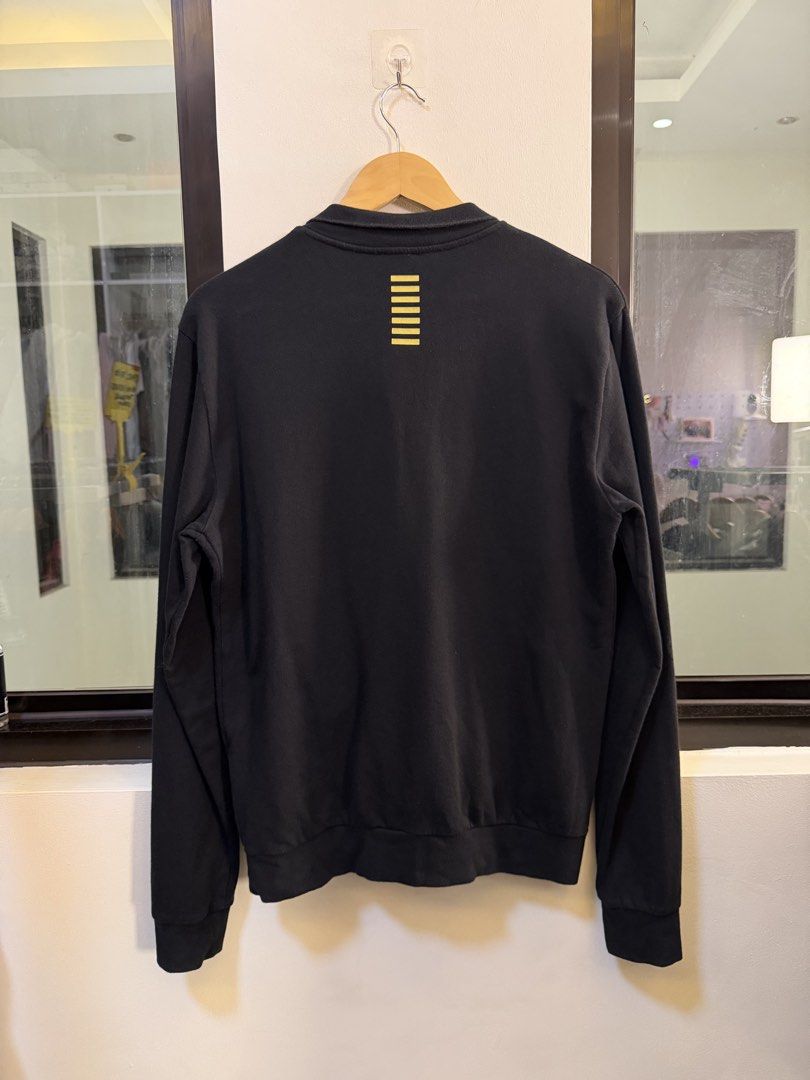 Emporio Armani Full-Zip Track Jacket (Category: Coats, Jackets and Outerwear) located in Paranaque City. Submitted by preluxeshop_ph (Listing ID 1470812638, Image 3). Description: Brand: EA7 Emporio Armani -Style: Full-Zip Track Jacket / Stand-Collar Sweatshirt -Color: Black with gold-tone accents -Design Features: Gold EA7 Emporio Armani logo on the left chest, gold signature vertical line graphic on the upper back collar, full front zip closure