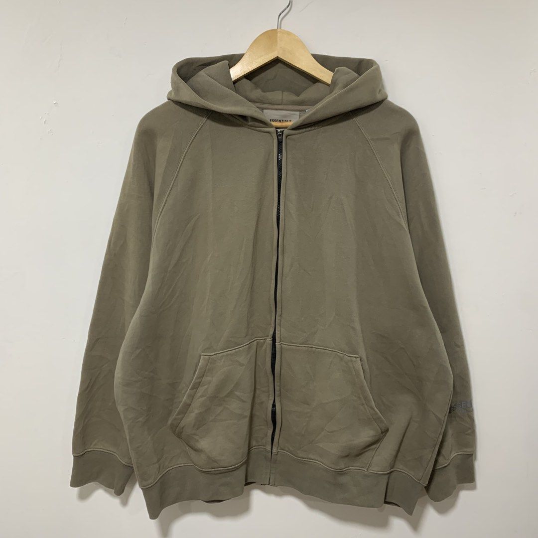 Essentials (Category: Hoodies) located in Cavite. Submitted by yobubsss (Listing ID 1470917652, Image 3). Description: - Brand: Essentials (Fear of God) - Style: Full-zip hoodie with front pockets - Color: Olive / Khaki Green - Size: Large (Made in Vietnam) - Features: Bold 'ESSENTIALS' back print, rubberized hood logo patch, sleeve branding - Condition: 7/10 pre-owned - Ideal for casual streetwear and comfortable daily wear.