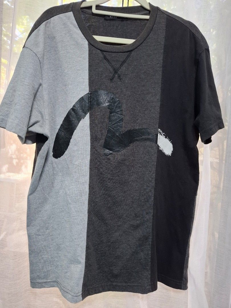 Evisu Colorblock T-Shirt Size 100 (Category: Tshirts & Polo Shirts ) located in Manila. Submitted by jazil.ladyliz (Listing ID 1470758414, Image 1). Description: - Brand: Evisu - Colorway: Grey, dark grey, and black colorblock - Design: Large front graphic print, ribbed neckline with cross-stitch detail, and mismatched color-blocked short sleeves - Fit & Size: Standard fit, tagged size 100 (Measures approx. 22" width x 28" length) - Condition: So