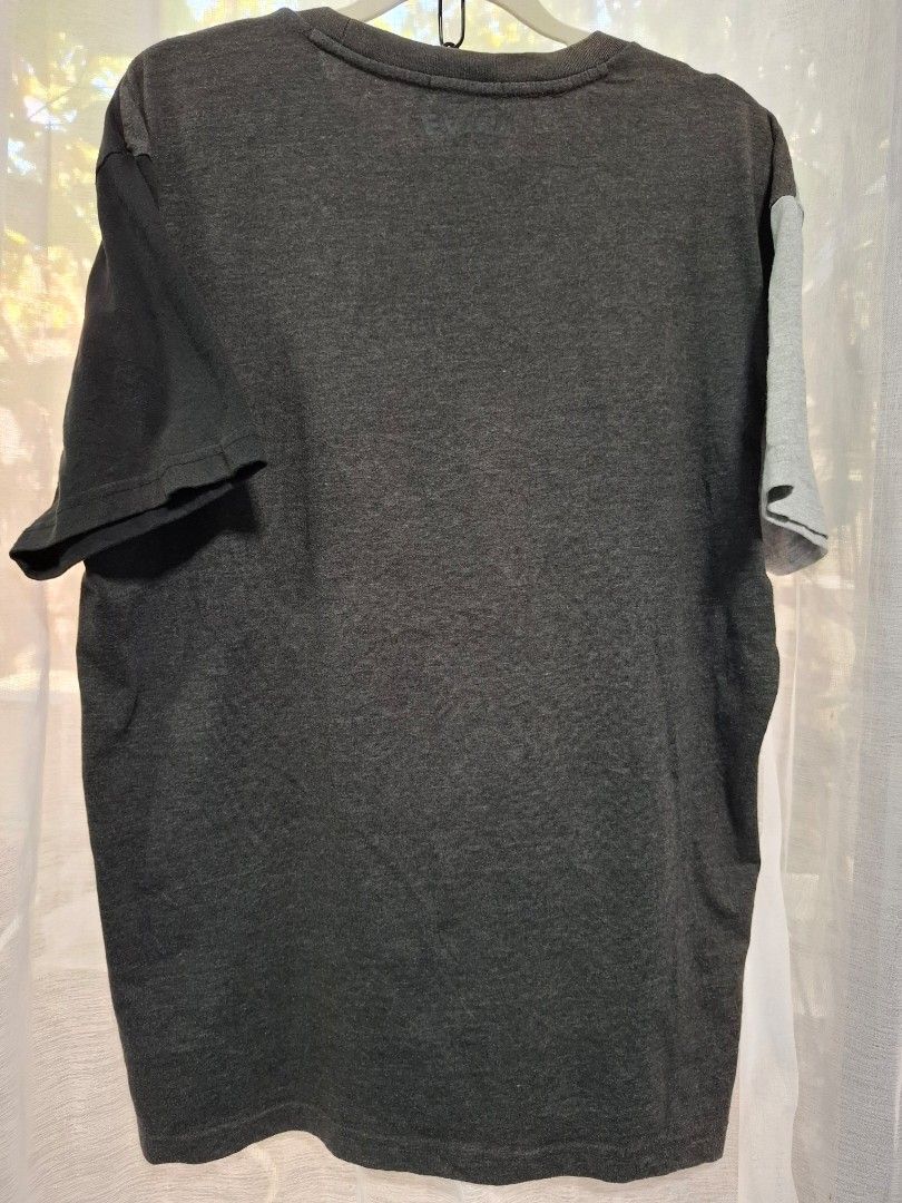 Evisu Colorblock T-Shirt Size 100 (Category: Tshirts & Polo Shirts ) located in Manila. Submitted by jazil.ladyliz (Listing ID 1470758414, Image 2). Description: - Brand: Evisu - Colorway: Grey, dark grey, and black colorblock - Design: Large front graphic print, ribbed neckline with cross-stitch detail, and mismatched color-blocked short sleeves - Fit & Size: Standard fit, tagged size 100 (Measures approx. 22" width x 28" length) - Condition: So
