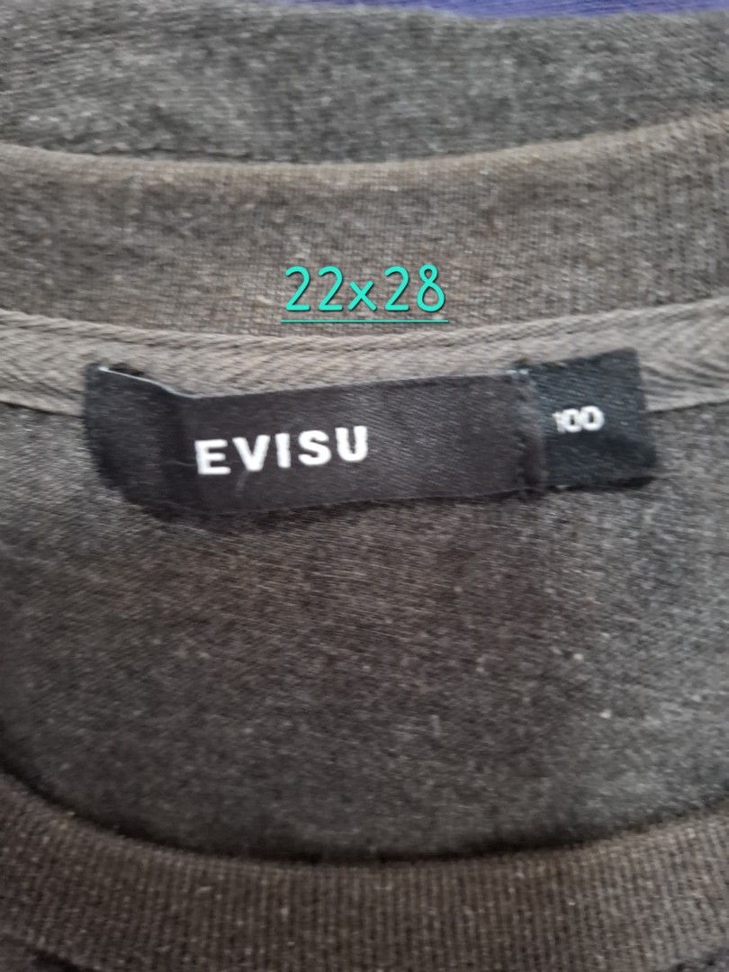 Evisu Colorblock T-Shirt Size 100 (Category: Tshirts & Polo Shirts ) located in Manila. Submitted by jazil.ladyliz (Listing ID 1470758414, Image 3). Description: - Brand: Evisu - Colorway: Grey, dark grey, and black colorblock - Design: Large front graphic print, ribbed neckline with cross-stitch detail, and mismatched color-blocked short sleeves - Fit & Size: Standard fit, tagged size 100 (Measures approx. 22" width x 28" length) - Condition: So