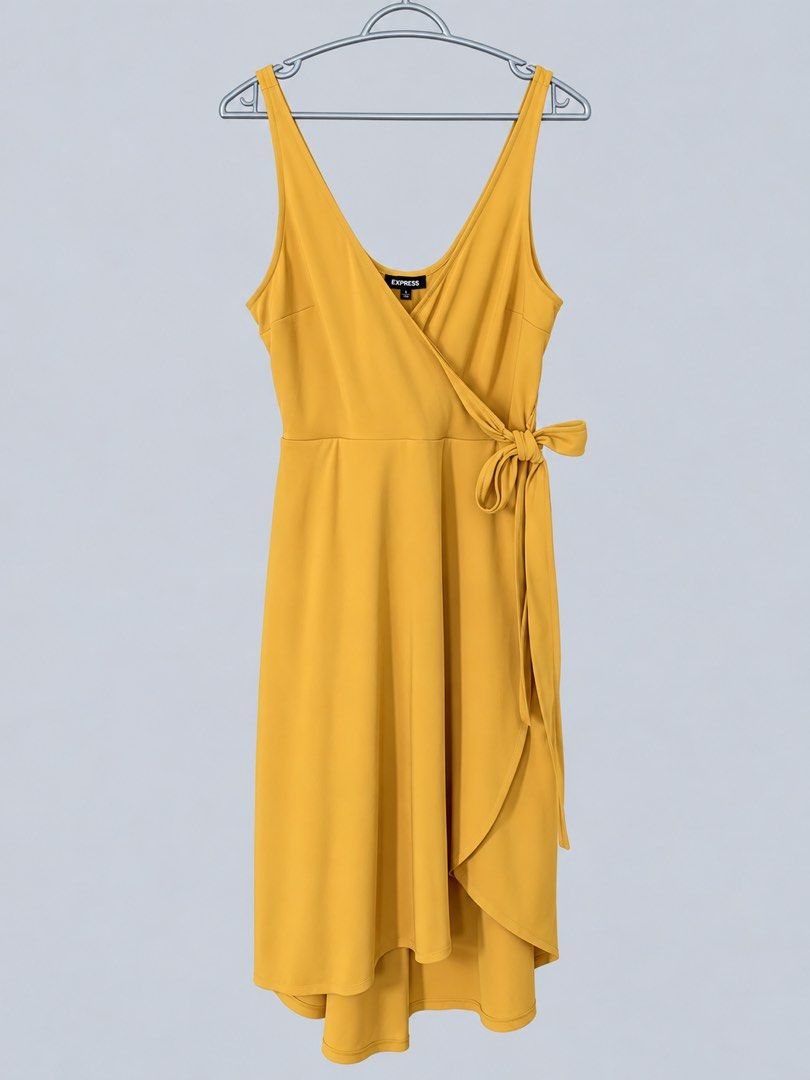EXPRESS Mustard Yellow Wrap Midi Dress (Category: Dresses) located in Bacoor. Submitted by goodfinds02 (Listing ID 1470843651, Image 1). Description: - Brand: Express - Color: Mustard Yellow - Style: Sleeveless wrap dress with thin straps - Neckline: V-neck front and scoop back - Details: Waist side tie bow - Hemline: Asymmetrical high-low - Fabric: Lightweight with a great drape.