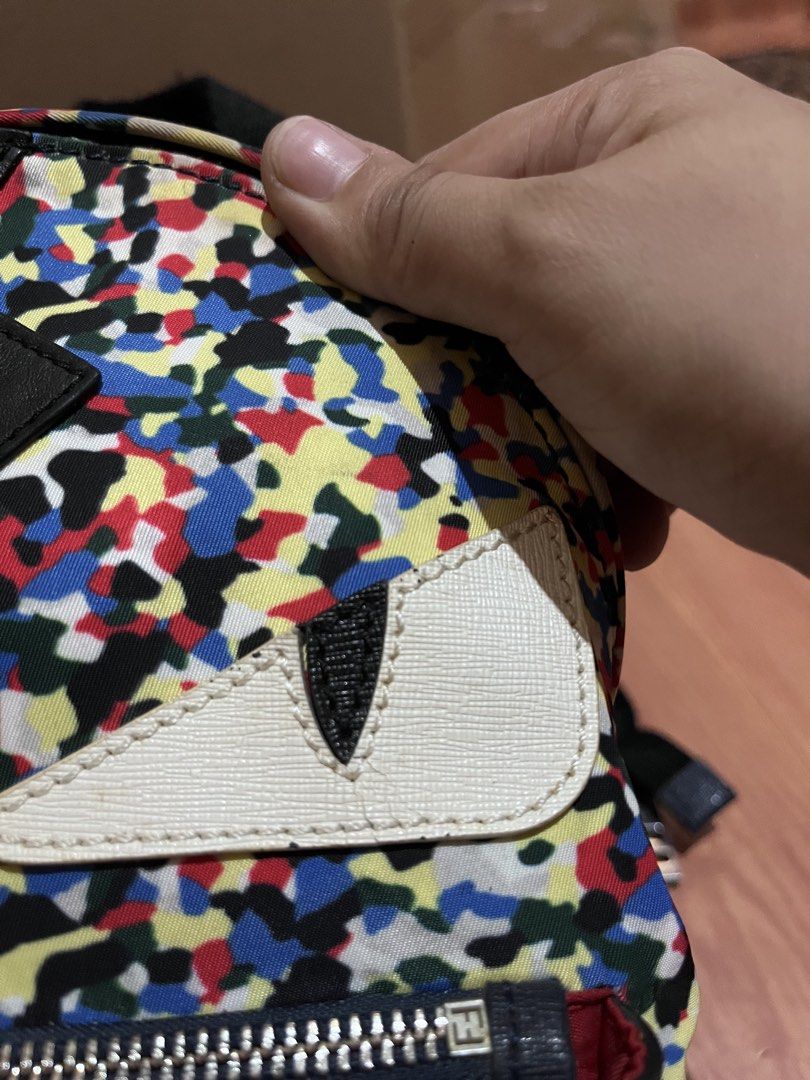 Fendi Monster Mini Backpack Multi-color Camo Lightning Bolt (Category: Backpacks) located in Manila. Submitted by madecuratedwithlove11 (Listing ID 1470887627, Image 3). Description: Fendi mini backpack in multi-color camouflage nylon. Front zipped pocket, iconic white leather monster eyes, and black leather lightning bolt applique. Top handle and adjustable shoulder straps. Interior black lining with Fendi Made in Italy leather tag. Hardware sho