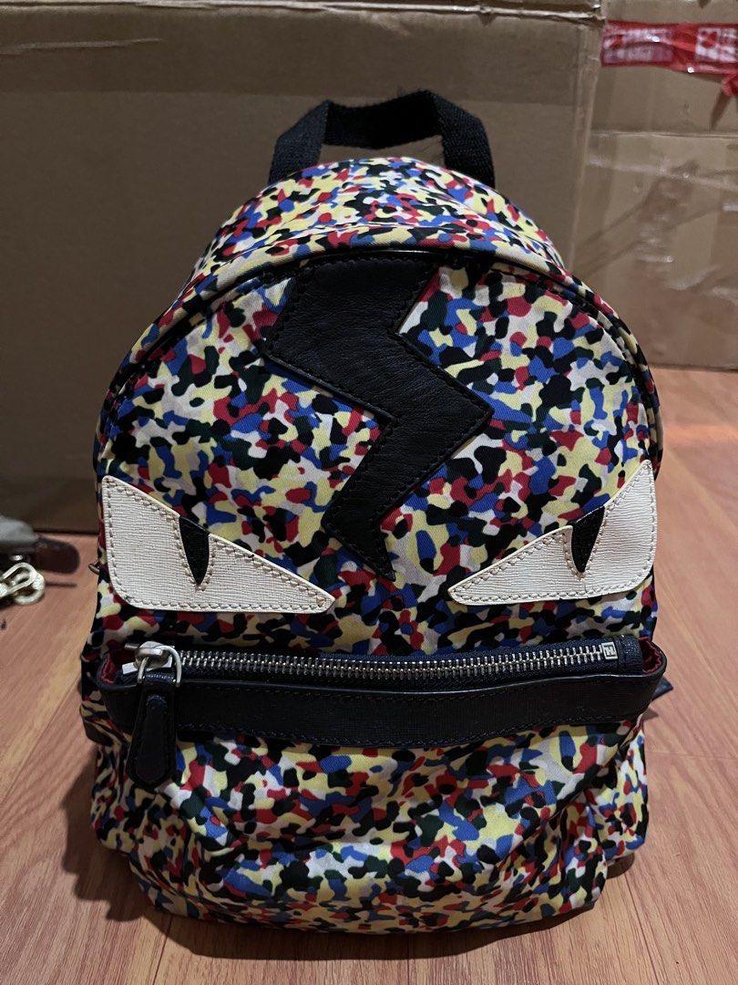 Fendi Monster Mini Backpack Multi-color Camo Lightning Bolt (Category: Backpacks) located in Manila. Submitted by madecuratedwithlove11 (Listing ID 1470887627, Image 2). Description: Fendi mini backpack in multi-color camouflage nylon. Front zipped pocket, iconic white leather monster eyes, and black leather lightning bolt applique. Top handle and adjustable shoulder straps. Interior black lining with Fendi Made in Italy leather tag. Hardware sho