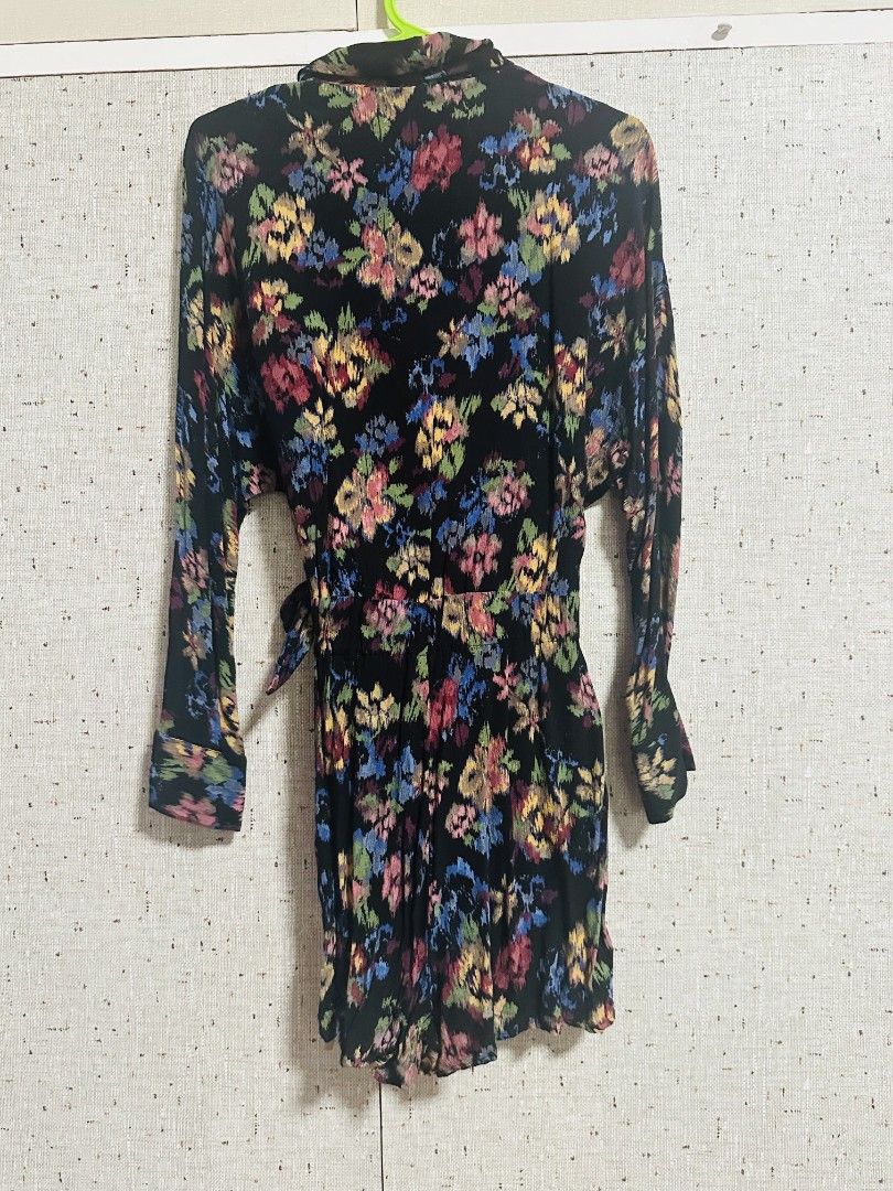 Floral Wrap Mini Romper with Long Sleeves (Category: Dresses) located in Manila. Submitted by thebestre (Listing ID 1470879391, Image 3). Description: - Color & Pattern: Black with a vibrant colourful floral print - Design: V-neck, long sleeves, and a flattering wrap style - Fit: Includes a matching fabric tie belt at the waist - Length: Short, hits above the knee - Material: Lightweight and comfortable - Styling Tip: Looks amazing paired with an