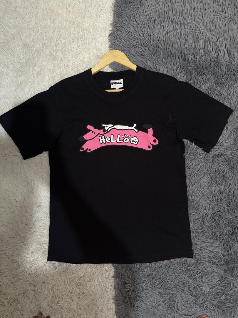 FNI Brand Black HELLO Graphic T-Shirt (Category: Shirts) located in Manila. Submitted by keepercollection (Listing ID 1470831733, Image 1). Description: - Brand: FNI - Size: Small (Pit to pit: ~19", Length: ~27") - Color: Black - Design: Chest graphic print with pink '' banner, white dog, and paw prints - Style: Standard short sleeve crewneck - Condition: Clean fabric with intact, clear neck tags.