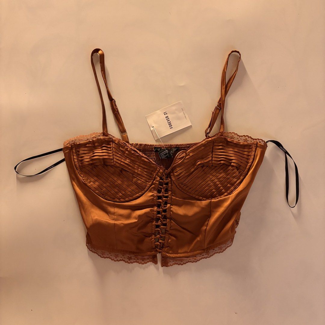 Forever 21 bronze Satin Corset Top (Category: Sleeveless) located in Quezon City. Submitted by tomatoes221 (Listing ID 1470757860, Image 1). Description: - Brand: Forever 21 - Condition: Brand new with tags (BNWT) - Size: Small - Color: Warm bronze with subtle sheen - Material: Smooth satin - Details: Ruched bust, delicate lace trim, adjustable spaghetti straps, and front lace-up corset closure.