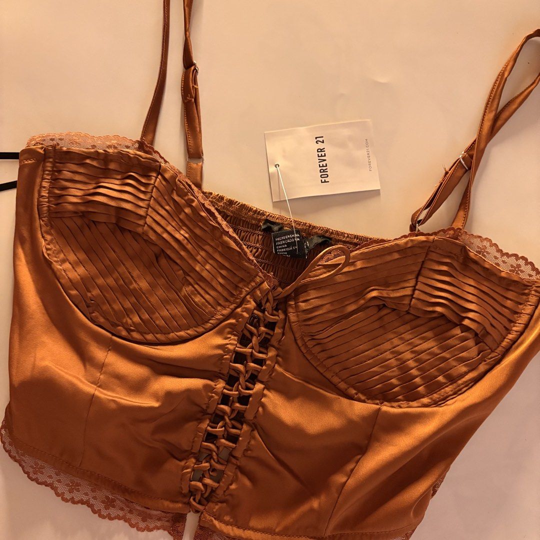 Forever 21 bronze Satin Corset Top (Category: Sleeveless) located in Quezon City. Submitted by tomatoes221 (Listing ID 1470757860, Image 2). Description: - Brand: Forever 21 - Condition: Brand new with tags (BNWT) - Size: Small - Color: Warm bronze with subtle sheen - Material: Smooth satin - Details: Ruched bust, delicate lace trim, adjustable spaghetti straps, and front lace-up corset closure.