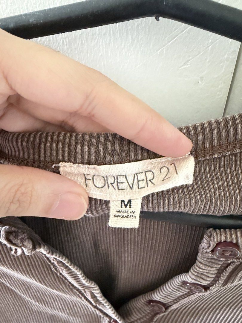 Forever 21 Brown Ribbed Button-Down Crop Top Size M (Category: Shirts) located in Manila. Submitted by mnlclaudia (Listing ID 1470791095, Image 2). Description: Brown ribbed crop top from Forever 21. Size M, made in Bangladesh. Short sleeves, scoop neckline with functional brown buttons down the front. Scalloped hemline. Stretchy cotton blend material. Worn a few times, washed and stored properly. Fits true to size, great basic piece for everyday