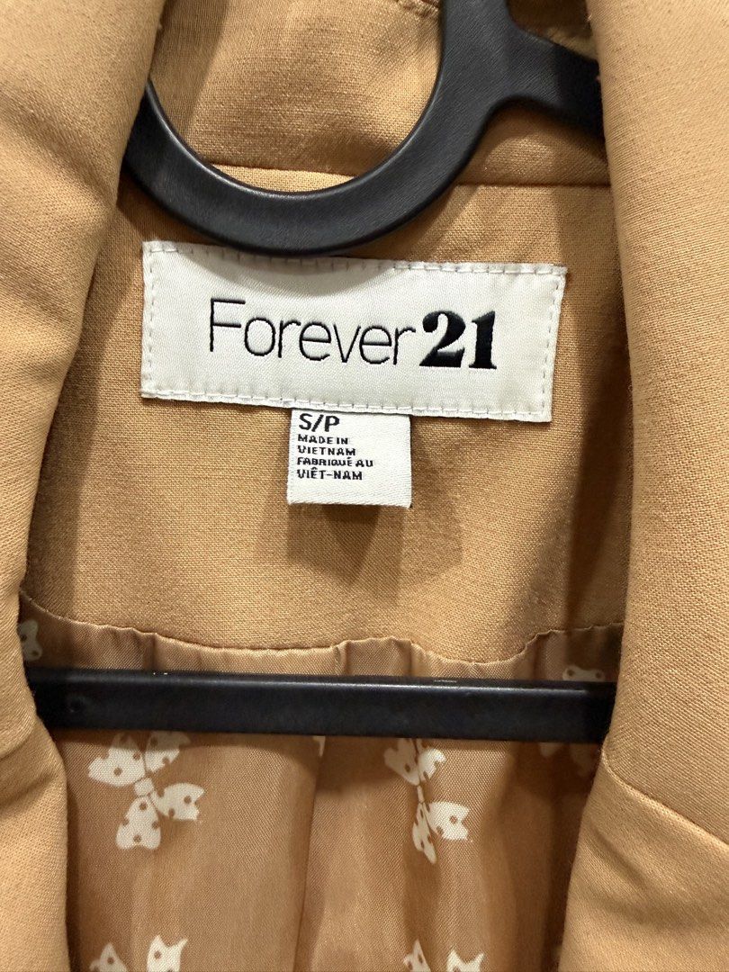 Forever 21 Camel Brown Blazer Size S (Category: Coats, Jackets and Outerwear) located in Taguig. Submitted by bau375 (Listing ID 1470795924, Image 2). Description: - Brand: Forever 21 - Color: Camel Brown - Size: S (tag attached) - Closure: Single button front - Details: Cute bow pattern inner lining, ruched sleeves with gathered cuffs - Pockets: Two front pockets plus a small chest pocket - Style: Great for layering over workwear or casual outfi