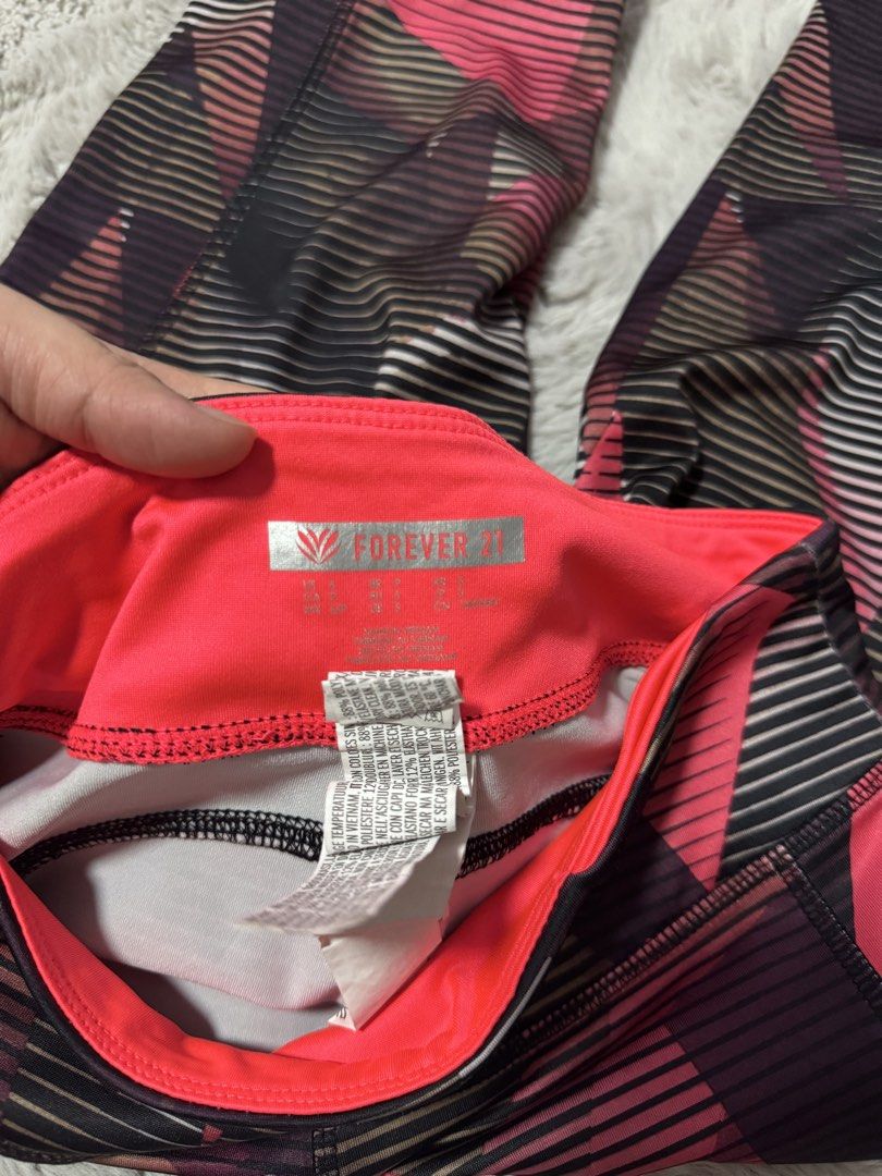 Forever 21 Geometric Print Active Leggings Size S (Category: Activewear) located in Calamba. Submitted by cheriiv (Listing ID 1470749085, Image 2). Description: - Brand: Forever 21 - Size: Small - Design: Bright pink, black, and grey geometric graphic pattern - Details: Neon pink inner waistband with a convenient hidden pocket - Fit: Full-length workout tights with a supportive stretch - Care: Machine washable synthetic material.