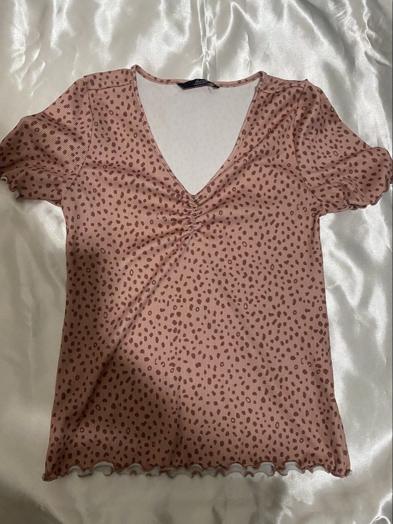 Forme Extra Small Pink Animal Print V-Neck Top (Category: Blouses) located in Rizal. Submitted by ssushimun (Listing ID 1470863161, Image 1). Description: - Brand: Forme - Size: XS (tag attached) - used once - Color/Pattern: Pink with brown animal/polka dot print - Details: V-neckline with ruched center, lettuce hem on sleeves and hemline - Fabric: Ribbed texture - Condition: Excellent, no major flaws spotted.