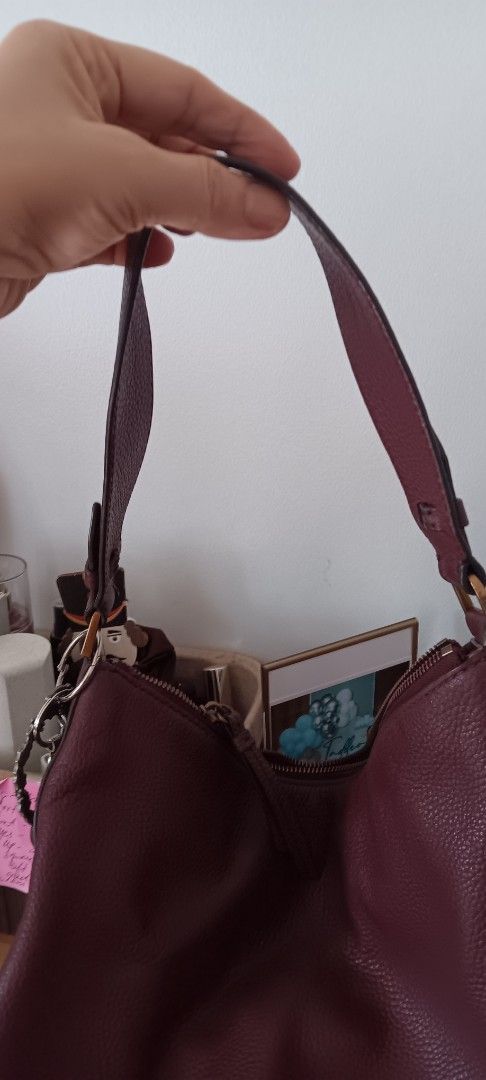 Fossil Burgundy Leather Shoulder Bag (Category: Shoulder Bags) located in Marikina City. Submitted by clivia_mommymade (Listing ID 1470848570, Image 3). Description: - Brand: Fossil - Material: Rich burgundy pebble leather - Hardware: Gold-tone - Strap: Adjustable for custom fit - Closure: Secure top zip - Interior: Brown fabric lining with multiple slip and zip pockets - Inclusions: Care booklet included - Condition: Well-maintained and stylish 