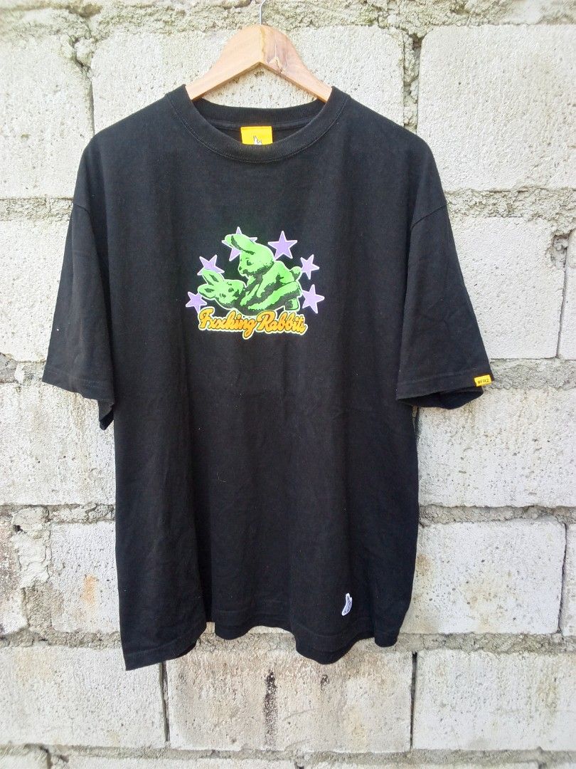FR2 Fxxking Rabbits Black Graphic Tee (Category: Tshirts & Polo Shirts ) located in Dinalupihan. Submitted by yanyan.thirft (Listing ID 1470921833, Image 1). Description: - Brand: FR2 (Fxxking Rabbits) - Color: Classic Black - Fit: Regular fit, crewneck style - Design: Eye-catching front chest graphic with neon green rabbits, purple stars, and orange lettering - Details: Signature yellow neck tag with rabbit logo and hashtag, plus a small woven l