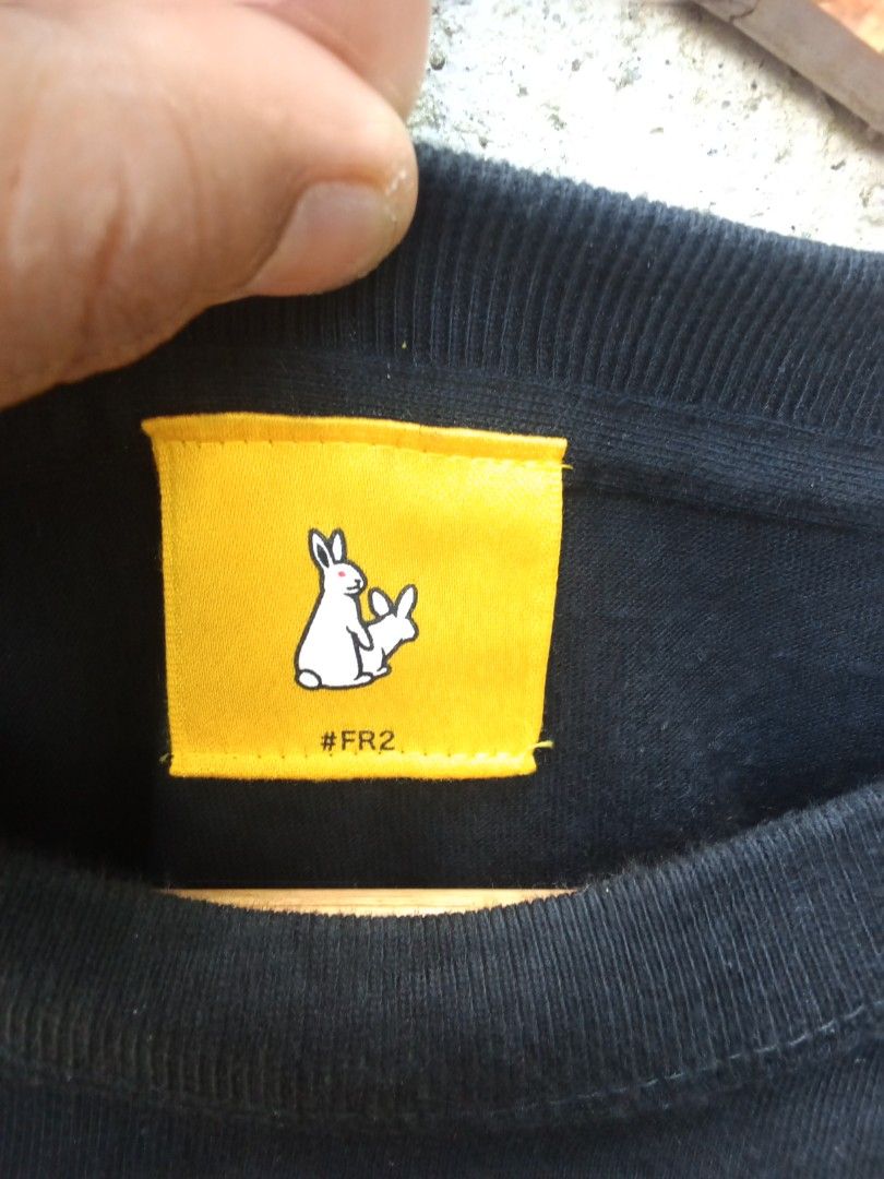FR2 Fxxking Rabbits Black Graphic Tee (Category: Tshirts & Polo Shirts ) located in Dinalupihan. Submitted by yanyan.thirft (Listing ID 1470921833, Image 3). Description: - Brand: FR2 (Fxxking Rabbits) - Color: Classic Black - Fit: Regular fit, crewneck style - Design: Eye-catching front chest graphic with neon green rabbits, purple stars, and orange lettering - Details: Signature yellow neck tag with rabbit logo and hashtag, plus a small woven l