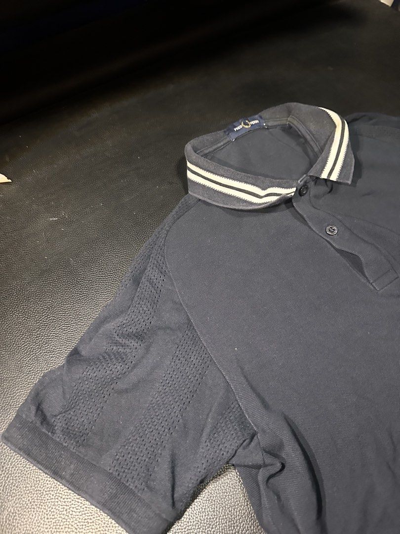 Fred Perry Navy Blue Polo Shirt Size M (Category: Tshirts & Polo Shirts ) located in Las Pinas. Submitted by boldbear_89ab40 (Listing ID 1470827052, Image 3). Description: - Brand: Fred Perry - Color: Dark Navy Blue - Size: Medium (tag on collar) - Details: Ribbed collar with white/dark stripes, iconic embroidered laurel wreath logo - Design: Breathable mesh patterned panels on shoulders and sleeves - Features: Short sleeves, front button placket