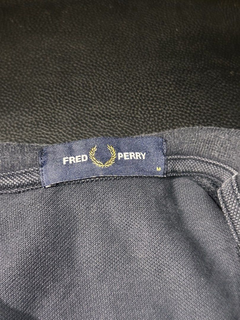Fred Perry Navy Blue Polo Shirt Size M (Category: Tshirts & Polo Shirts ) located in Las Pinas. Submitted by boldbear_89ab40 (Listing ID 1470827052, Image 2). Description: - Brand: Fred Perry - Color: Dark Navy Blue - Size: Medium (tag on collar) - Details: Ribbed collar with white/dark stripes, iconic embroidered laurel wreath logo - Design: Breathable mesh patterned panels on shoulders and sleeves - Features: Short sleeves, front button placket