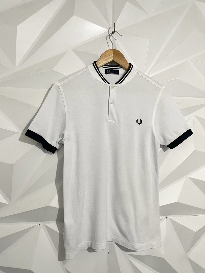 Fred Perry White Polo Shirt (Category: Tshirts & Polo Shirts ) located in Cabuyao City. Submitted by ParadisethriftedPh (Listing ID 1470924492, Image 2). Description: Cr: 9.8/10 Dimensions W: 18.5 L: 26 - Brand: Fred Perry - Color: White with black tipping on collar and cuffs - Size: S - Material: 100% cotton (Made in China) - Details: Classic two-button placket, embroidered black laurel wreath on chest - Condition: Clean fabric, internal tags at