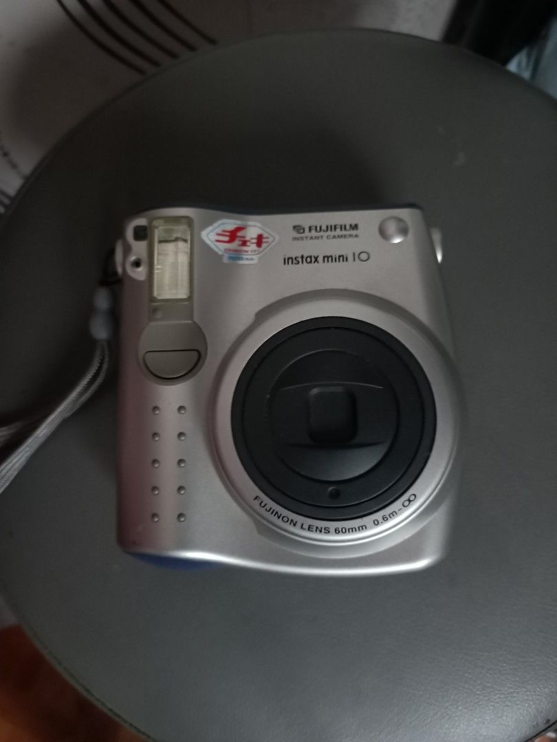 Fujifilm Instax Mini 10 Instant Camera Silver (Category: Cameras) located in Taguig. Submitted by grandfish_55ab5c (Listing ID 1470882611, Image 1). Description: - Model: Silver Fujifilm Instax Mini 10 instant camera - Lens: Fujinon 60mm lens - Focus: Manual focus settings from 0.6m to infinity - Flash & Exposure: Built-in flash with lighten and darken controls - Extras: Wrist strap attached included - Power: Side battery compartment (easy access