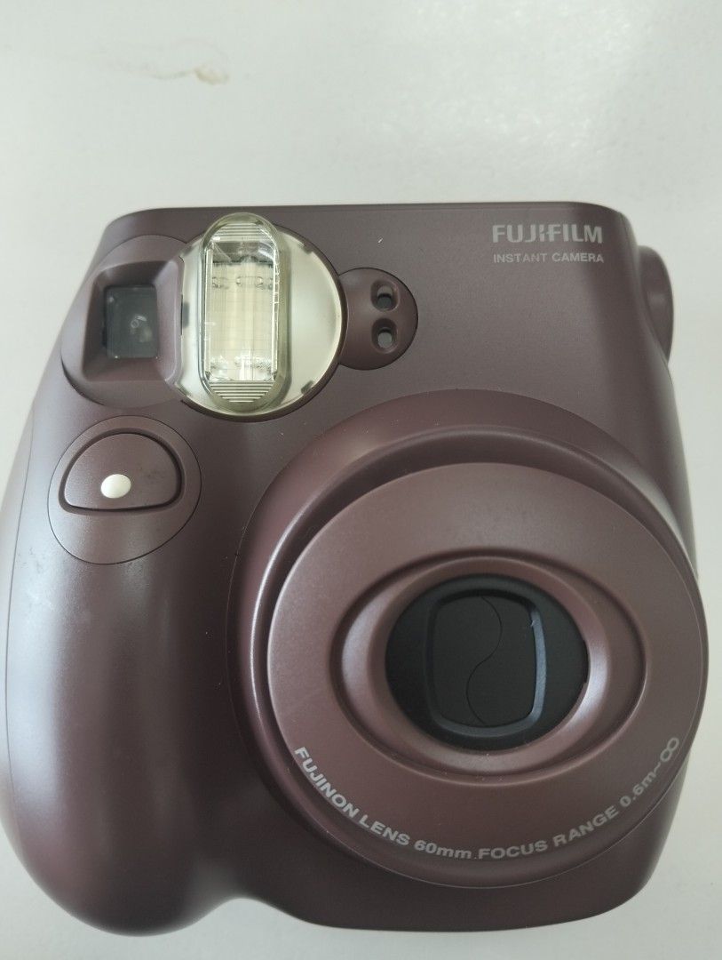 Fujifilm Instax Mini 7S Brown Instant Camera (Category: Cameras) located in Marikina City. Submitted by aisha.escarez21 (Listing ID 1470903925, Image 1). Description: - Model: Fujifilm Instax Mini 7S Instant Camera - Color: Chocolate Brown - Lens: Fujinon 60mm (0.6m to infinity focus) - Exposure: Manual adjustment dial on top - Condition: Clean film chamber and battery compartment - Film Type: Uses standard Instax Mini film - Perfect for: Parties
