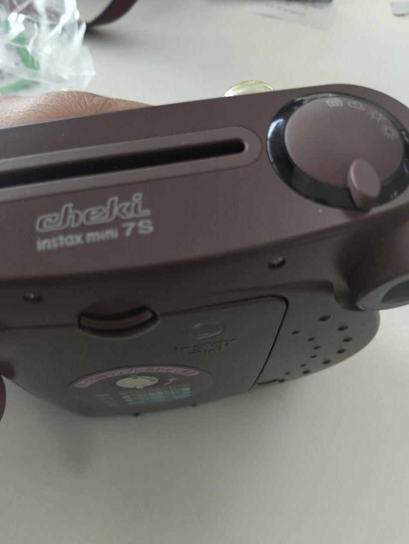 Fujifilm Instax Mini 7S Brown Instant Camera (Category: Cameras) located in Marikina City. Submitted by aisha.escarez21 (Listing ID 1470903925, Image 2). Description: - Model: Fujifilm Instax Mini 7S Instant Camera - Color: Chocolate Brown - Lens: Fujinon 60mm (0.6m to infinity focus) - Exposure: Manual adjustment dial on top - Condition: Clean film chamber and battery compartment - Film Type: Uses standard Instax Mini film - Perfect for: Parties