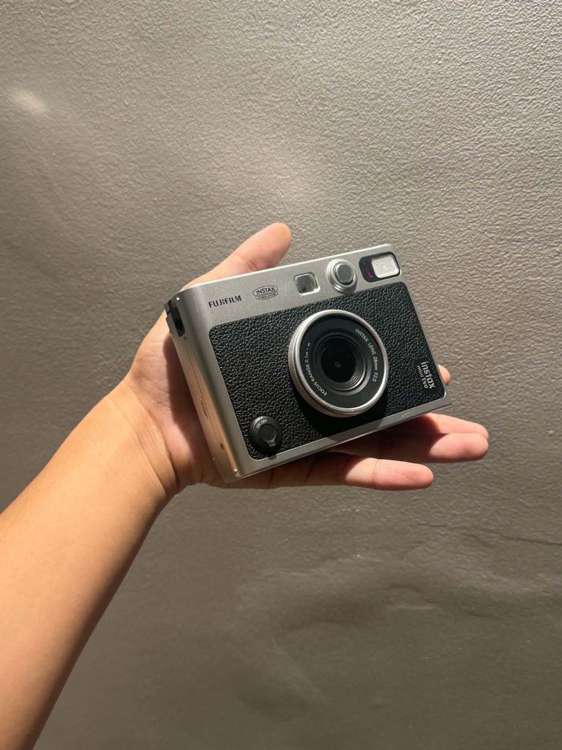 Fujifilm Instax Mini Evo Hybrid Instant Camera with Case (Category: Cameras) located in Pateros City. Submitted by maurjss (Listing ID 1470908845, Image 2). Description: - Model: Fujifilm Instax Mini Evo Hybrid Instant Camera - Color: Classic Silver & Black finish - Condition: Tested and fully functional - Features: Rear LCD screen with intuitive control buttons, print digital photos instantly - Inclusions: Matching black leatherette half case wi