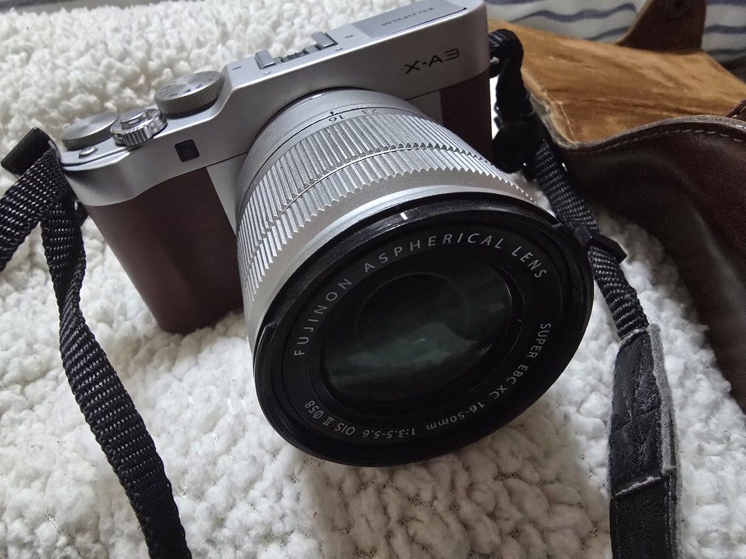 Fujifilm X-A3 (Category: Cameras) located in Cavite. Submitted by maknaelala6 (Listing ID 1470878665, Image 2). Description: - Model: Fujifilm X-A3 Mirrorless Camera Body (Silver/Brown) - Lens: Fujinon XC 16-50mm f/3.5-5.6 OIS II (clean glass) - Condition: Fully functional, flip-up screen works perfectly - Extras: Matching brown leather half case and black neck strap included - Ideal for: Beginners looking for a stylish and reliable interchangeab