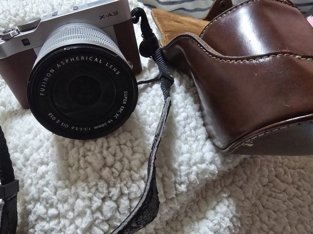 Fujifilm X-A3 (Category: Cameras) located in Cavite. Submitted by maknaelala6 (Listing ID 1470878665, Image 1). Description: - Model: Fujifilm X-A3 Mirrorless Camera Body (Silver/Brown) - Lens: Fujinon XC 16-50mm f/3.5-5.6 OIS II (clean glass) - Condition: Fully functional, flip-up screen works perfectly - Extras: Matching brown leather half case and black neck strap included - Ideal for: Beginners looking for a stylish and reliable interchangeab