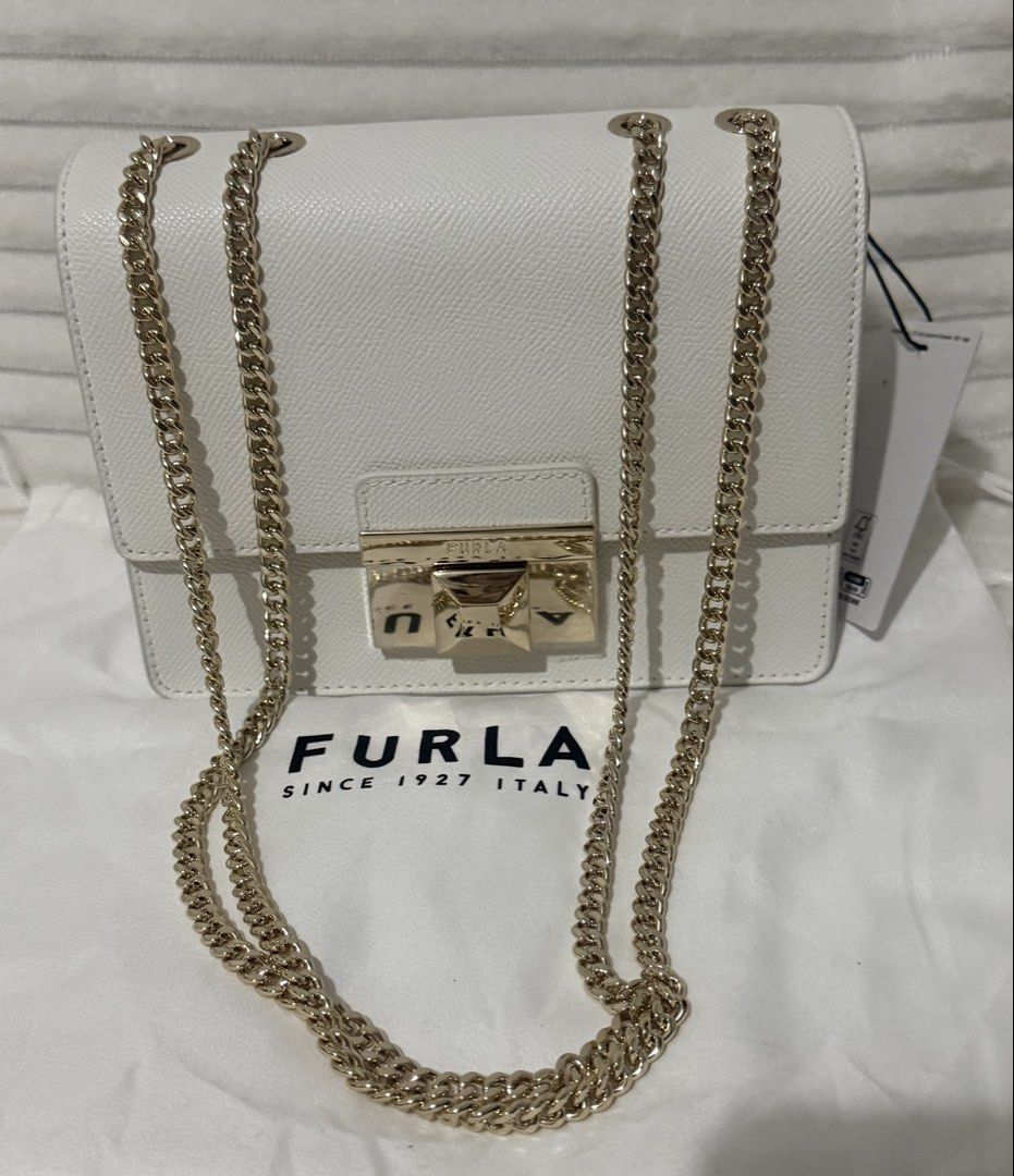 Furla Venere Crossbody MINI White Bag (Category: Cross-body Bags) located in Las Pinas. Submitted by purse.vanity (Listing ID 1470833146, Image 3). Description: - Brand: Furla - Model: Venere Crossbody MINI - Color: White - Condition: Brand new, never used, pristine condition - Material: Textured leather finish - Hardware: Gold-tone chain strap and metal push-lock closure (protective plastic film still attached) - Inclusions: Original tag, care c