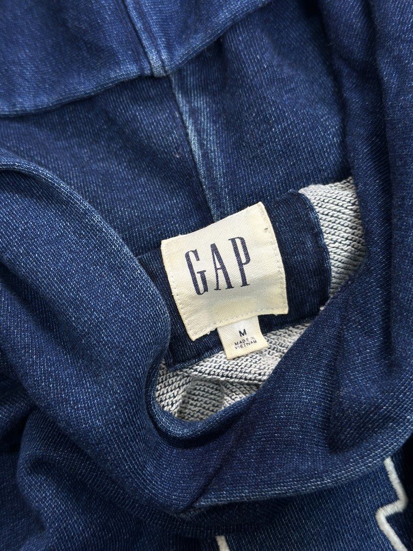 GAP Pigmented Denim Washed Hoodie Size M (Category: Coats, Jackets and Outerwear) located in Daet. Submitted by thrifthings2018 (Listing ID 1470845554, Image 2). Description: - Brand: GAP - Style: Pigmented denim washed hoodie - Color: Classic navy blue with large white chest logo - Size: Medium (Width: 24", Length: 28") - Details: Front kangaroo pocket, lined hood, ribbed cuffs and hem - Origin: Made in Vietnam - Condition: Excellent vintage loo