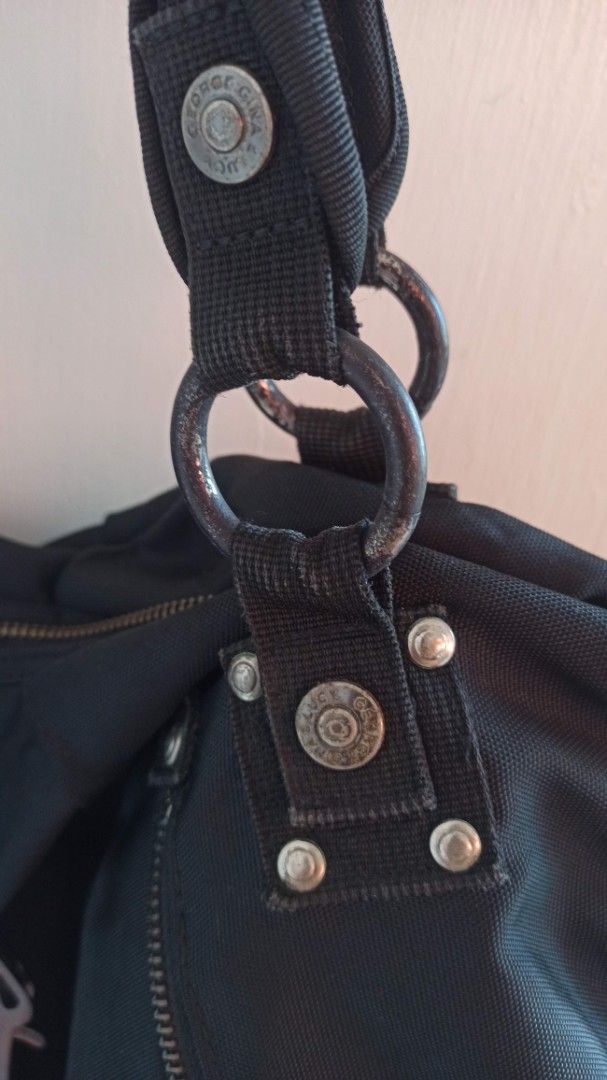 George Gina & Lucy Black Shoulder Bag (Category: Shoulder Bags) located in Santa Teresita. Submitted by icecandy2.0 (Listing ID 1470819646, Image 2). Description: - Brand: George Gina & Lucy - Material: Durable black canvas with gray fabric lining - Storage: Multiple exterior zipped compartments and interior zipper pocket - Closure: Distinctive metal snap-hook and branded hardware details - Condition: Good, with minor wear on the metal rings conn